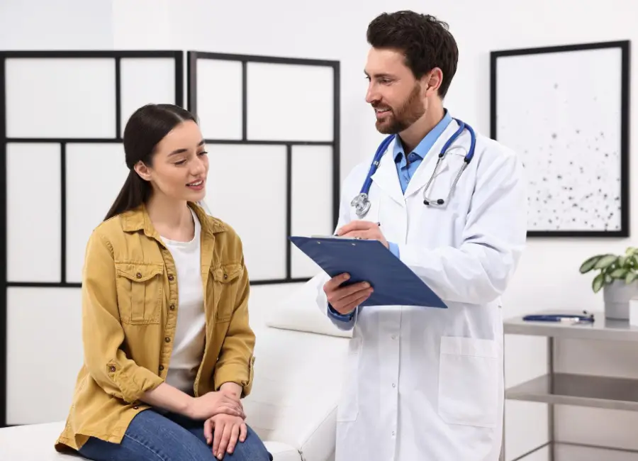 Doctor and patient smiling during an annual physical exam.