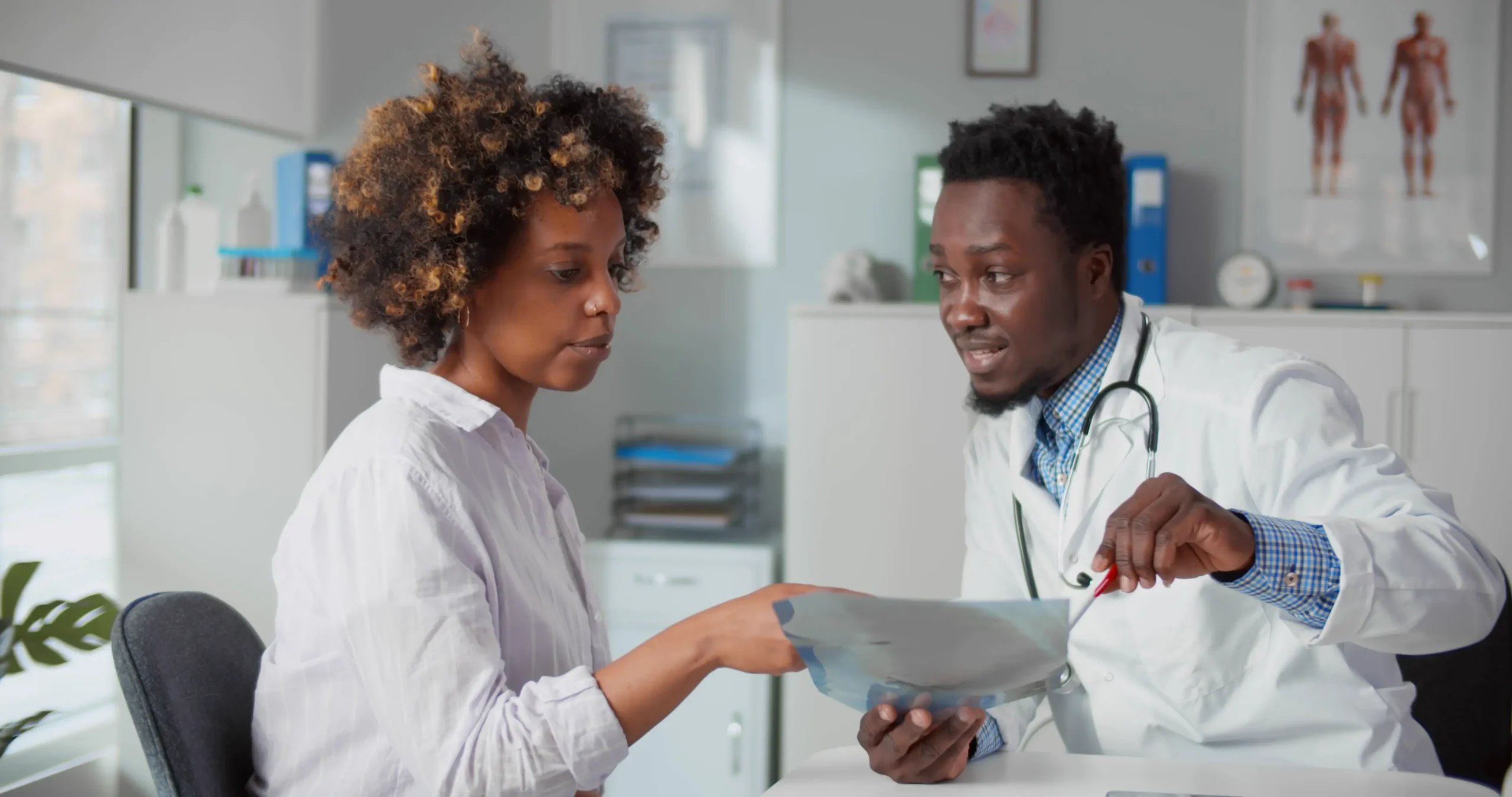 Doctor showing health test results to a patient on a tablet.